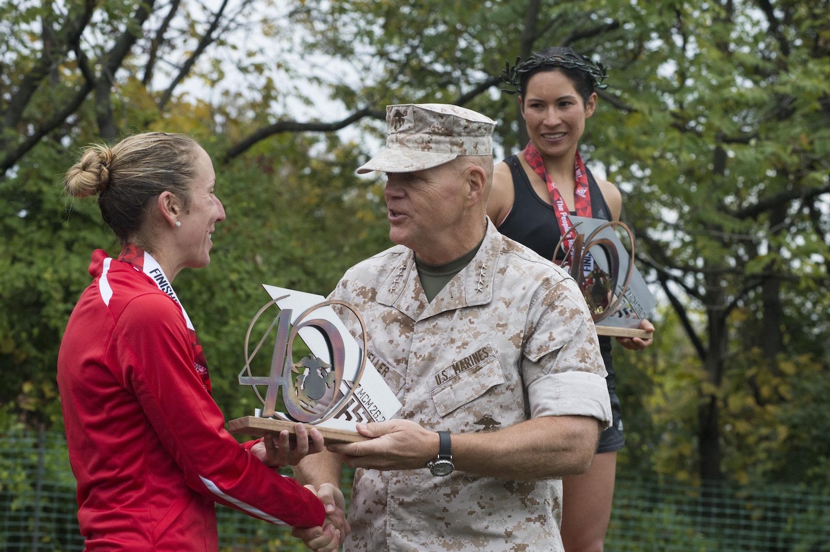 U.S. Marine Corps Capt. Christine Taranto of Monterey, Calif., receives a trophy from the 37th Commandant of the Marine Corps, General Robert B. Neller, for 2nd place female finisher of the 40th Marine Corps Marathon at the awards ceremony in Arlington, Va., Oct. 25, 2015. Also known as "The People's Marathon," the 26.2 mile race drew roughly 30,000 participants to promote physical fitness, generate goodwill in the community, and showcase the organizational skills of the Marine Corps. (U.S. Marine Corps photo by Staff Sgt. Sarah R. Hickory/Released)