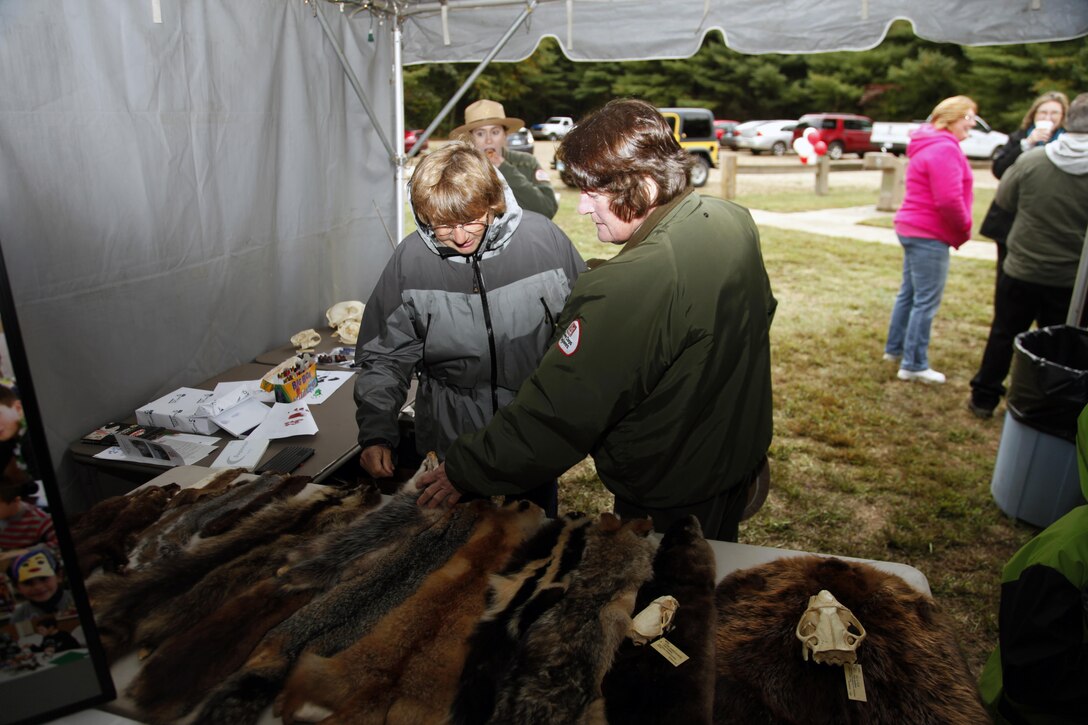 Park Ranger Claudia Hixson answers questions from a participant about the furs and skulls during West Thompson Lake's 50th Anniversary, October 3, 2015.