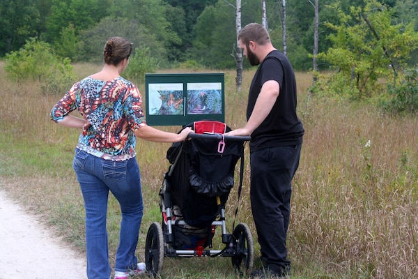 Parents read the story panel to their young child as they made their way through the story walk.