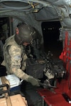 Army Sgt. Joe Loscheider, a flight engineer with B Company, 2-211th General Support Aviation Battalion, Minnesota National Guard, prepares to move his M240B machine gun into position prior to heading out on a mission from Camp Taji, Iraq, on Oct. 7, 2011.