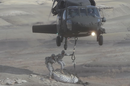 Company C, 1st Battalion, 171st Aviation, UH-60 Black Hawk crew consisting of pilots Maj. Daniel Purcell and Capt. Kevin Doo, and crew chiefs Sgt. 1st Class Dennis Cahill and Sgt. Saul Monarez airlift a unique sling load of a baby Pentaceratops dinosaur skull out of the Bisti/De-na-zin Wilderness Area Oct. 29, 2015. Sgt. Bryan Haworth and Spc. Alonzo Romero, both of 1st Battalion 200th Infantry, hook the 4,500 pounds load onto the belly of the aircraft. 