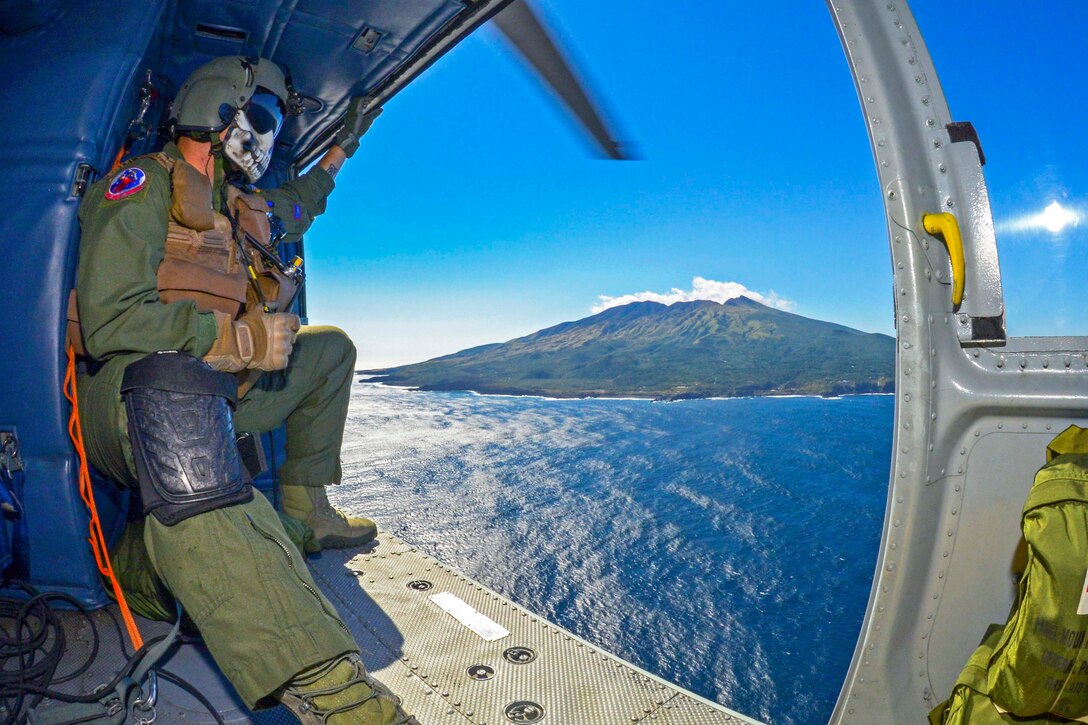 U.S. Air Force Staff Sgt. Christopher Rector, watches the scenery off the coast of Tokyo, Oct. 28, 2015. Rector, a 459th Airlift Squadron special missions aviator, and the flight crew delivered simulated medical supplies during a Tokyo Metropolitan Government disaster relief exercise. U.S. Air Force photo by Airman 1st Class Elizabeth Baker
