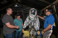Alan Mendiola, 502nd Civil Engineer Squadron Emergency Management, describes a level A Hazmat suit to Jessica and David Swierzynski during the 2015 Joint Base San Antonio Air Show and Open House Nov. 1, 2015 at JBSA-Randolph, Texas. Air shows allow the Air Force to display the capabilities of our aircraft to the American taxpayer through aerial demonstrations and static displays and allowing attendees to get up close and personal to see some of the equipment and aircraft used by the U.S. military today. (U.S. Air Force photo by Johnny Saldivar) 
