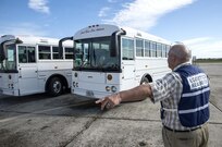 Joseph Smoak, 502nd Logistics Readiness Squadron ground transportation operations chief, guides buses to the air show entrance during the 2015 Joint Base San Antonio Air Show and Open House Oct. 31, 2015 at JBSA-Randolph, Texas. Air shows allow the Air Force to display the capabilities of our aircraft to the American taxpayer through aerial demonstrations and static displays and allowing attendees to get up close and personal to see some of the equipment and aircraft used by the U.S. military today. (U.S. Air Force photo by Johnny Saldivar) 
