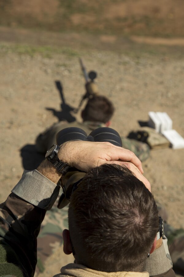 A Marine with Company C, 1st Marine Raider Battalion, U.S. Marine Corps Forces, Special Operations Command spots for his teammate, who is firing at distant, static targets on a range aboard Marine Corps Base Camp Pendleton, Calif., Oct. 7, 2015. Marine Special Operations Company C spent the first phase of their three-phase Company Collective Exercise practicing Foreign Internal Defense aboard Marine Corps Base Camp Pendleton, Calif., Oct. 5-8.