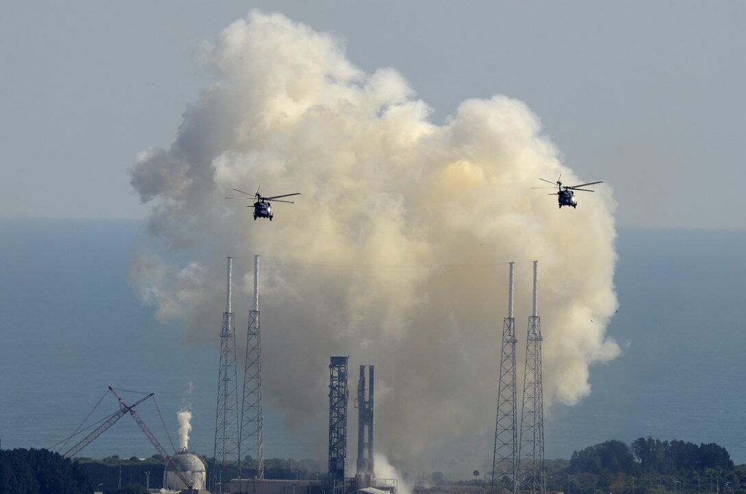 Air Force Reservists from the 920th Rescue Wing, Patrick Air Force Base, Florida, race away in two HH-60G Pave Hawk helicopters as a United Launch Alliance Atlas V rocket is launched carrying a Boeing-built Global Positioning System IIF satellite from Space Launch Complex 41, Cape Canaveral Air Force Station, Oct. 31. The 920th RQW is responsible for clearing and securing the Eastern Rocket Range prior to all Space Coast rocket launches. (U.S. Air Force photo/Maj. Cathleen Snow)