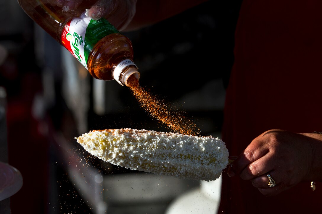 A vendor prepares elote, or corn on the cob, during the annual Latino Heritage Festival in Des Moines, Iowa, Sept. 26, 2015. This elote is bathed in mayonnaise, sprinkled with cheese and topped with mild spices. DoD photo by EJ Hersom