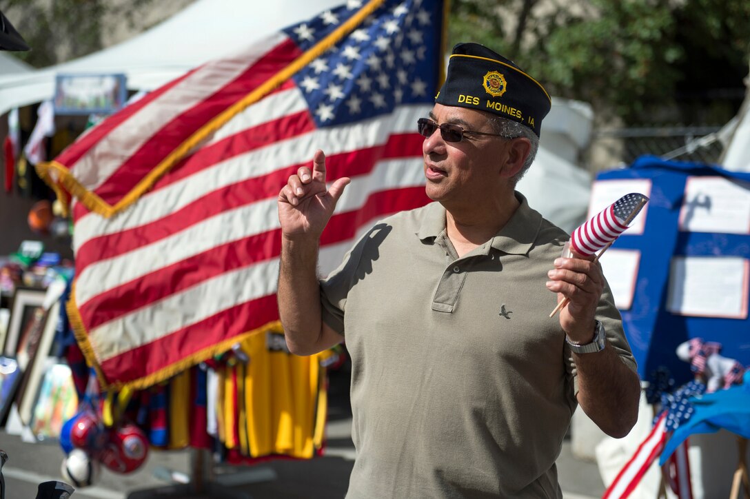 Marine Corps veteran Albert Martinez responds to a greeting while volunteering with the American Legion at the annual Latino Heritage Festival in Des Moines, Iowa, Sept. 27, 2015. DoD photo by EJ Hersom