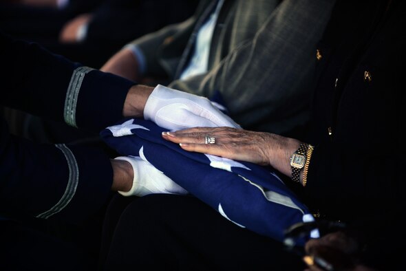 Staff Sgt. Richard Bates, the honor guard NCO in charge, presents the flag to retired Maj. Gen. Homer I. Lewis’ wife Ingrid in Eagle Pass, Texas, on Oct. 28, 2015. Upon presentation of the flag, the presenter says, “On behalf of the president of the United States, and a grateful nation, please accept this flag as a symbol of our appreciation for your loved one's honorable and faithful service.” (U.S. Air Force photo/Tech. Sgt. Steven R. Doty) 
