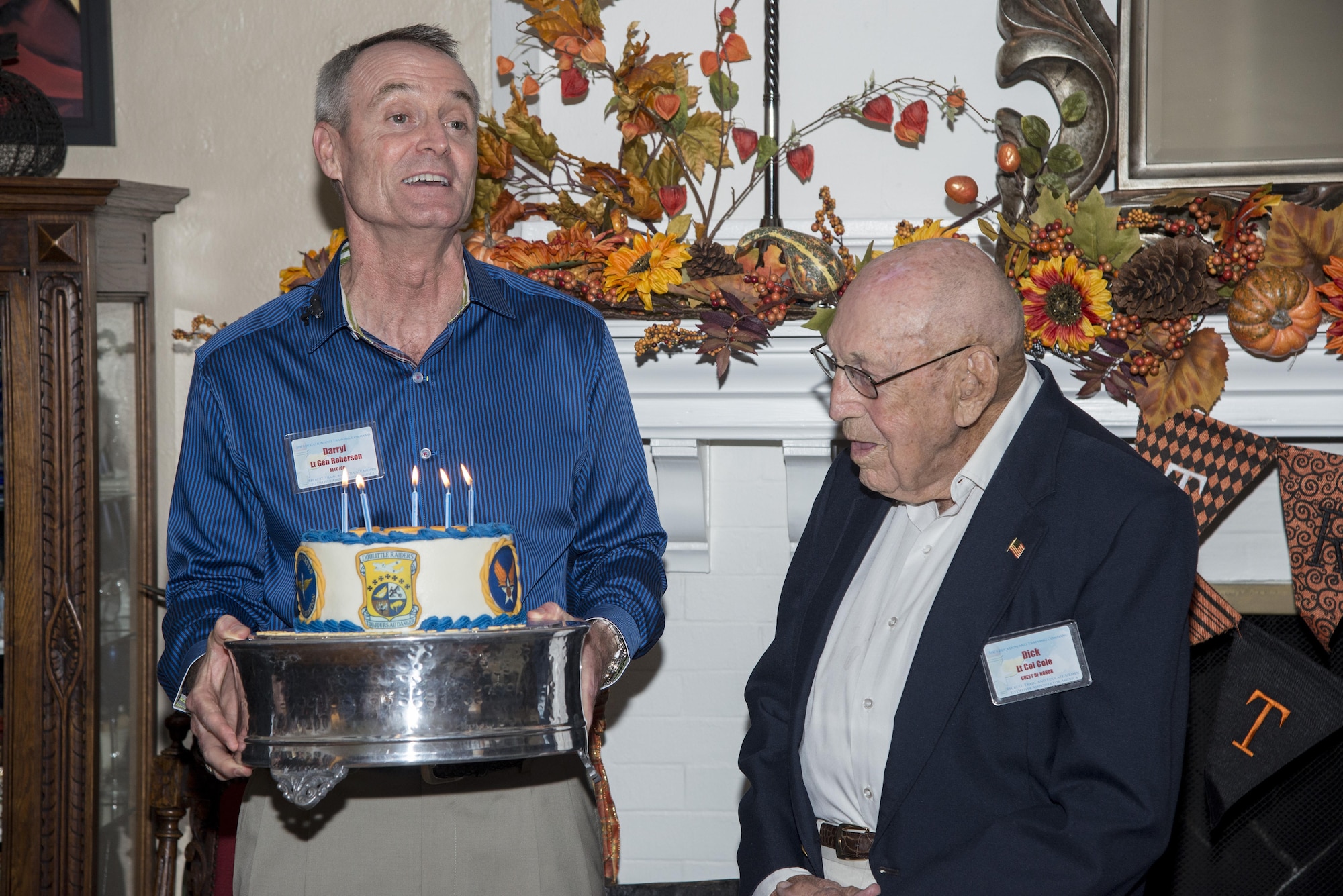 Lt. Gen. Darryl Roberson, commander of Air Education and Training Command, presents a birthday cake to retired Lt. Col. Richard Cole, Doolittle Raider, during Cole’s 100th birthday celebration Oct. 30, 2015, at Joint Base San Antonio-Randolph. The reception afforded General Roberson and attendees an opportunity to interact with an individual who represents a linkage to Air Force heritage. The event also bridged the past and present, and offered Airmen a chance to interact with a living legend.  (U.S. Air Force photo by Airman 1st Class Stormy Archer/Released)
