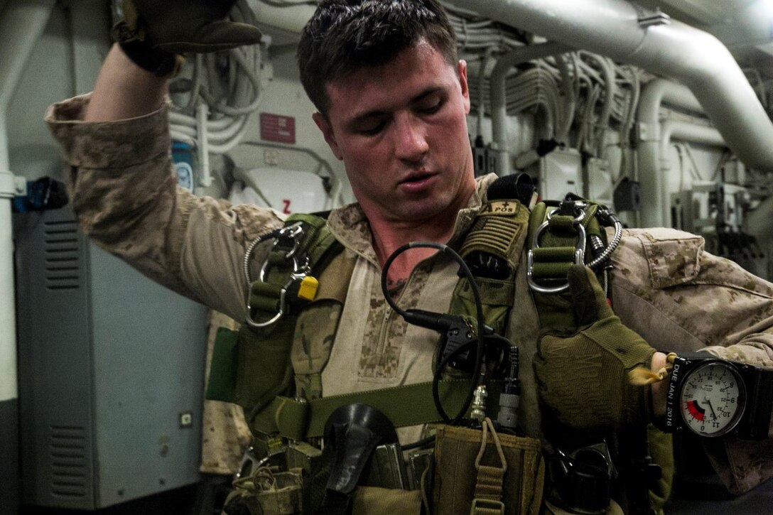 U.S. Marine Cpl. Tyler O'Reilly with the Maritime Raid Force, 13th Marine Expeditionary Unit (MEU), performs operational checks of his parachute devices as his team conducts gear inspections during the Composite Training Unit Exercise (COMPTUEX) aboard the USS Boxer, at sea, Oct. 29, 2015. COMPTUEX provides the MEU ARG the opportunity to integrate naval training while also allowing focused, mission-specific training and evaluation for the Marines and their Navy counter parts. (U.S. Marine Corps photo by Cpl. Briauna Birl/RELEASED)