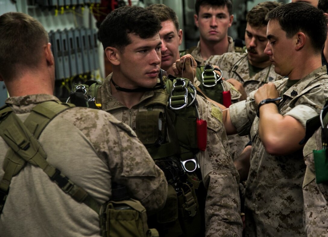 U.S. Marines with the Maritime Raid Force, 13th Marine Expeditionary Unit (MEU), work as a team to ensure parachutes are in proper working order  during the Composite Training Unit Exercise (COMPTUEX) aboard the USS Boxer, at sea, Oct. 29, 2015. COMPTUEX provides the MEU ARG the opportunity to integrate naval training while also allowing focused, mission-specific training and evaluation for the Marines and their Navy counter parts. (U.S. Marine Corps photo by Cpl. Briauna Birl/RELEASED)