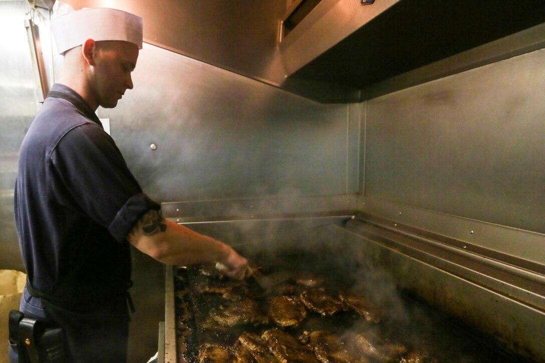 GULF OF ADEN (Oct. 29, 2015) U.S. Navy Sailor Petty Officer 1st Class David Johnson prepares steaks for the October birthday dinner aboard the USS Anchorage (LPD 23). Johnson is a culinary specialist aboard the Anchorage.  Marines and Sailors celebrated their birthdays for the month of October with a steak and lobster tail dinner served by their staff noncommissioned officers. The 15th Marine Expeditionary Unit, embarked on the ships of the Essex Amphibious Ready Group, is deployed to maintain regional security in the U.S. 5th Fleet area of operations. (U.S. Marine Corps photo by Sgt. Jamean Berry/Released)