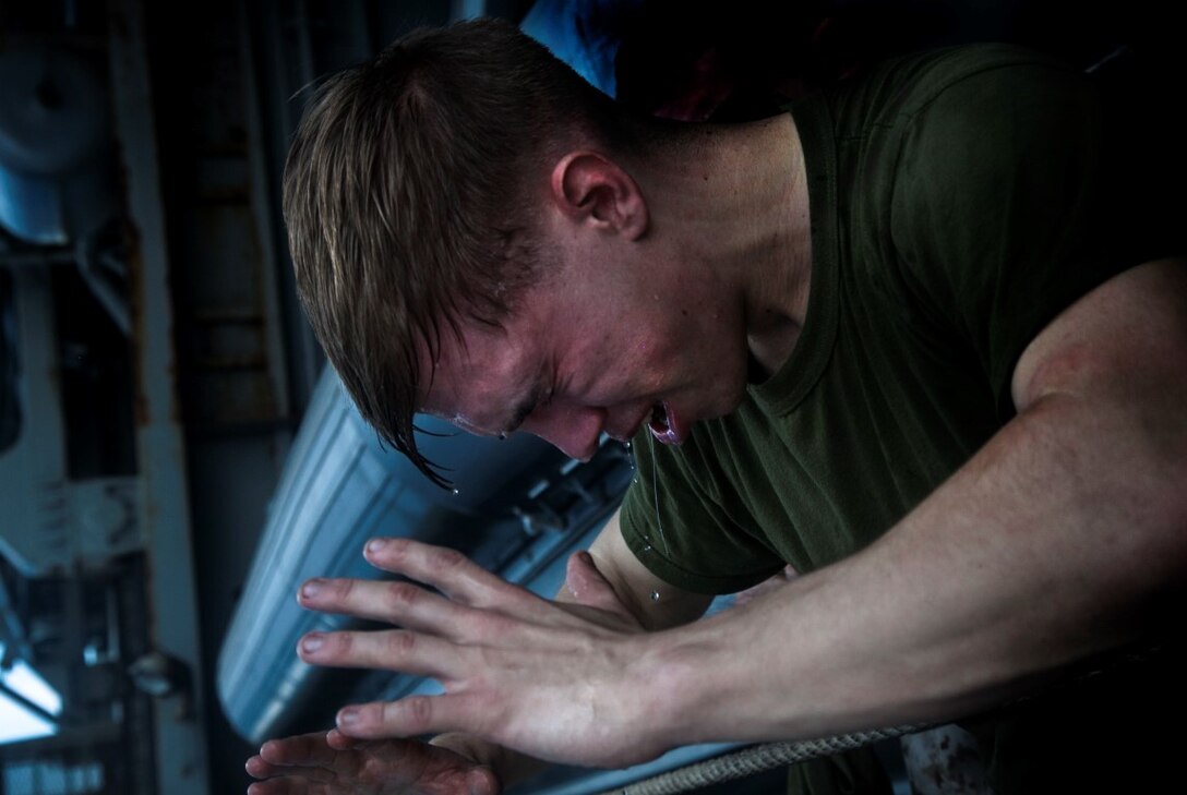 INDIAN OCEAN (Oct. 31, 2015) U.S. Marine Cpl. Nicholas Robinson washes his face after being sprayed with oleoresin capsicum in the hangar bay of the amphibious assault ship USS Essex (LHD 2). The Marines and Sailors are going through a non-lethal weapons course to learn different techniques they might need while on watch-stander duty. (U.S. Marine Corps photo by Cpl. Elize McKelvey/Released)