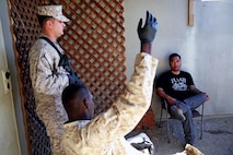 Marines with Headquarters and Service Company, 1st Battalion, 5th Marine Regiment, 1st Marine Division, speak with a role-playing suspect while searching his house during searchers and site exploitation training aboard Marine Corps Base Camp Pendleton, Calif., Oct. 29, 2015. Instructors with the Marines Corps Engineer Society taught the Marines the skills they need to locate and collect evidence on munitions or against suspected individuals in a realistic training environment.