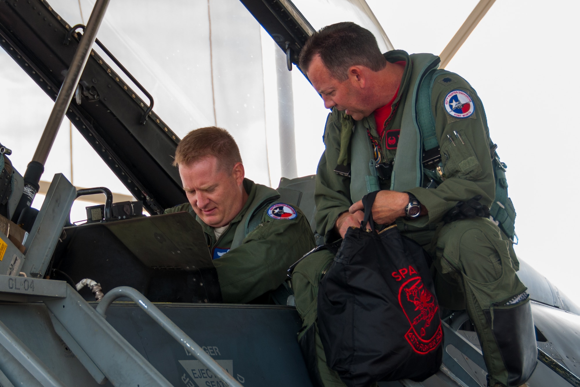 U.S. Air Force Reserve Lt. Col. David Efferson (left), commander of the 457th Fighter Squadron at Naval Air Station, Joint Reserve Base Fort Worth, Texas, and Lt. Col. Bryan Bailey (right), 307th Bomb Wing, Barksdale Air Force Base, La., prepare for a flight in an F-16 Fighting Falcon on Oct. 23, 2015. The members of his father’s squadron, the 457th “Spads,” honored Bailey, who followed in his father’s footsteps by becoming an Air Force pilot, with a surprise incentive ride. Bailey’s father, Maj. John Bailey died in an F-4 aircraft crash near Carswell AFB, Texas, in 1987. (U.S. Air Force photo by Master Sgt. Laura Siebert/Released)
