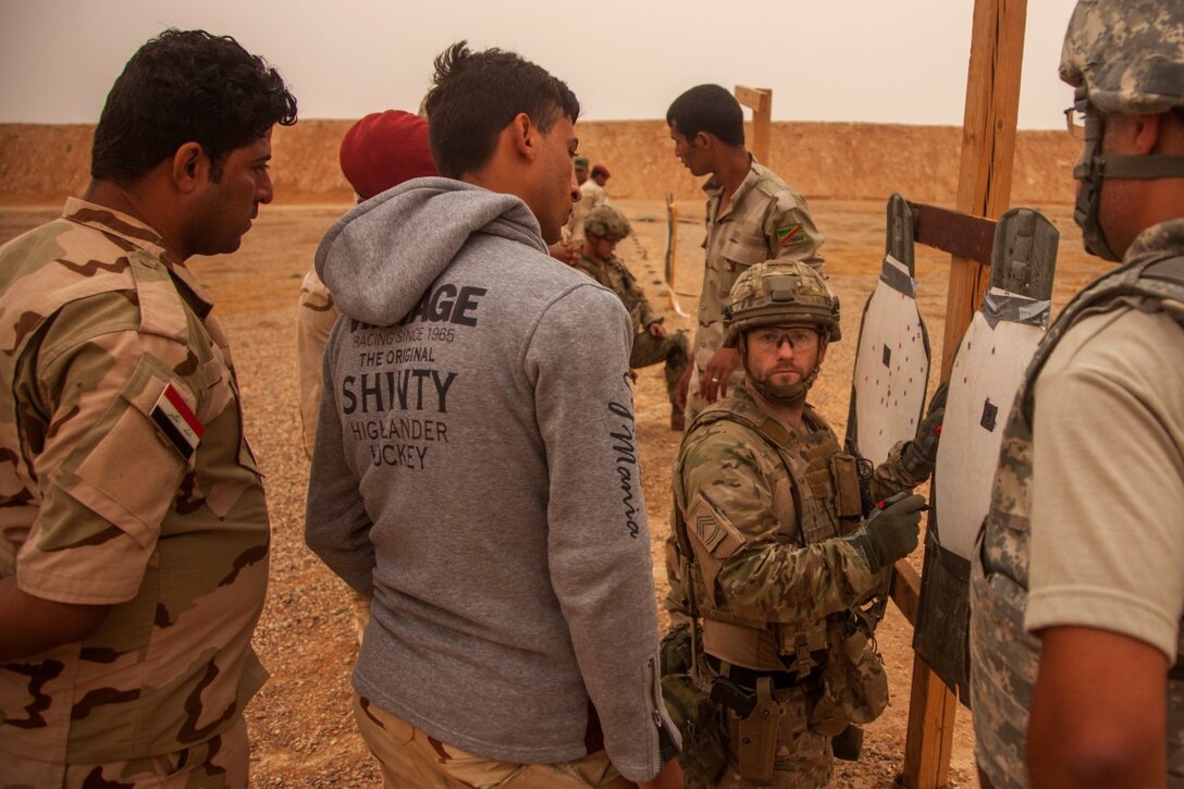 Royal Danish Army soldiers evaluate the targets of Iraqi soldiers with the 7th Iraqi Army Division during advanced marksmanship training with M16A4 rifles at Al Asad Air Base, Iraq, Oct. 25, 2015. The Danish soldiers are supporting Combined Joint Task Force – Operation Inherent Resolve’s building partner capacity mission. By enabling Iraqi Security Forces through advise and assist and build partner capacity missions, the multinational coalition is helping the Government of Iraq to set the conditions to defeat the Islamic State of Iraq and the Levant. (U.S. Marine Corps photo by Cpl. Akeel Austin/Released)