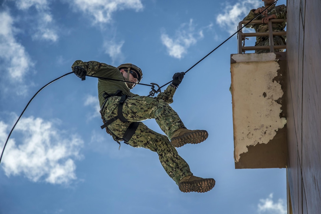 A sailor conducts rope-suspension techniques on Naval Base Guam, Oct. 29, 2015. The sailor is an explosive ordnance disposal technician assigned to EOD Mobile Unit 5 and EOD Mobile Unit 6. U.S. Navy photo by Petty Officer 2nd Class Daniel Rolston 
