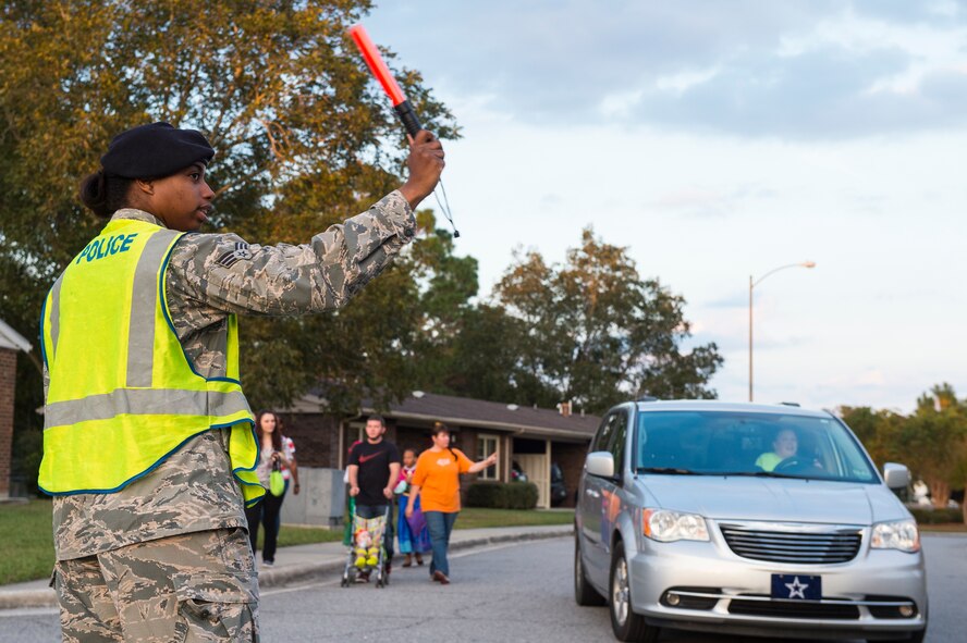 U.S. Air Force Senior Airman Shawna Dublin, 23d Security Forces Squadron installation entry controller, directs traffic during trick or treat hours Oct. 31, 2015, at Moody Air Force Base, Ga. Members of the 23d SFS and 820th Base Defense Group marshalled traffic and families to ensure everyone remained safe while participating in the festivities. (U.S. Air Force photo by Senior Airman Ceaira Tinsley/Released)
