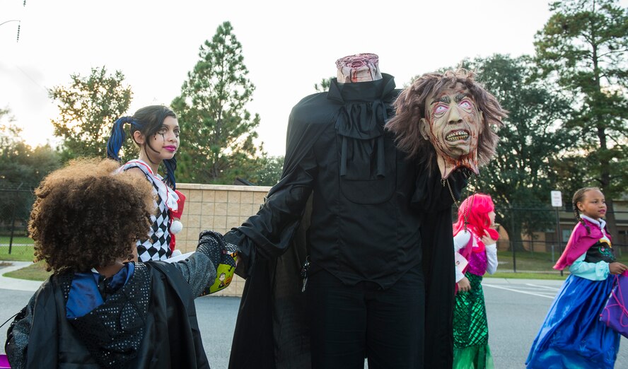 Nia, daughter of U.S. Air Force Chief Master Sgt. Arris Hill, 822d Base Defense Squadron, receives candy from Alexis Ruth, Trunk or treat participant, Oct. 31, 2015, at Moody Air Force Base, Ga. Hundreds of families participated in Moody’s Trunk or Treat event at the youth center and trick or treating at Quiet Pines base housing. (U.S. Air Force photo by Senior Airman Ceaira Tinsley/Released)