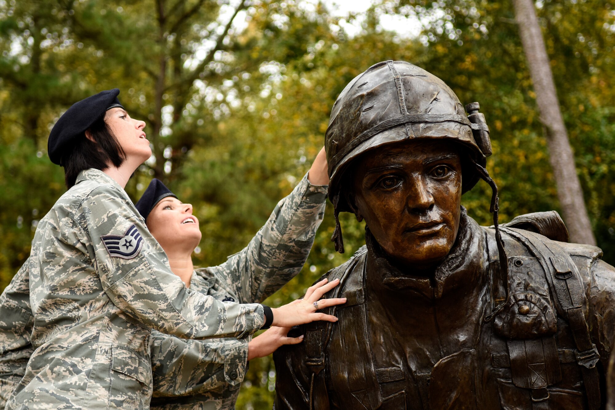 Staff Sgts. Nicole Gilley (front) and Kristina Dennison, 4th Security Forces Squadron military working dog handlers, read the inscriptions on the War Dog Memorial statue, Oct. 27, 2015, at Seymour Johnson Air Force Base, North Carolina. Carved into the statue’s helmet are multiple identification numbers assigned to former MWDs along with various other symbols. (U.S. Air Force photo/Airman Shawna L. Keyes)  