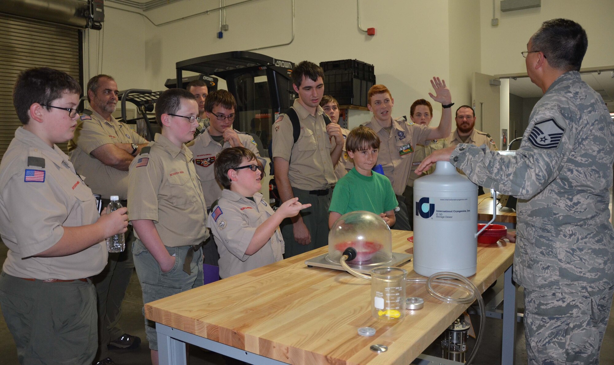 Master Sgt. Chad Taguba (right) a physicist with the Air Force Technical Applications Center, Patrick AFB, Fla., demonstrates what happens when liquid nitrogen is placed in an extremely low-pressure environment, exhibiting a unique property of matter known as a substance’s ‘triple point' to a group of Boy Scouts who visited the center to meet the requirements for earning a Nuclear Science Merit Badge Oct. 24, 2015.  (U.S. Air Force photo by Susan A. Romano)