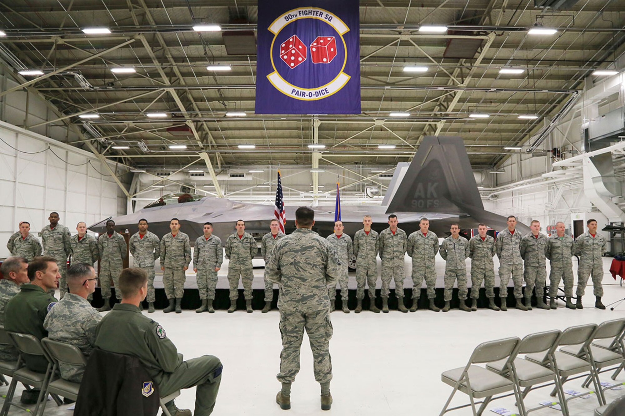 F-22 Raptor crew chiefs assigned to the 90th Fighter Squadron are recognized during a Dedicated Crew Chief Ceremony on Joint Base Elmendorf-Richardson Oct. 23. During the ceremony, crew chiefs were recognized for their dedication and hard work. Every Raptor has a dedicated crew chief assigned who is trusted with the care and maintenance of the jet. At the ceremony the Airmen received coins from their respective commanders, certificates certifying them as DCCs, and new maintenance overalls to designate them as such while on the flight line. (U.S. Air Force photo/Alejandro Pena)