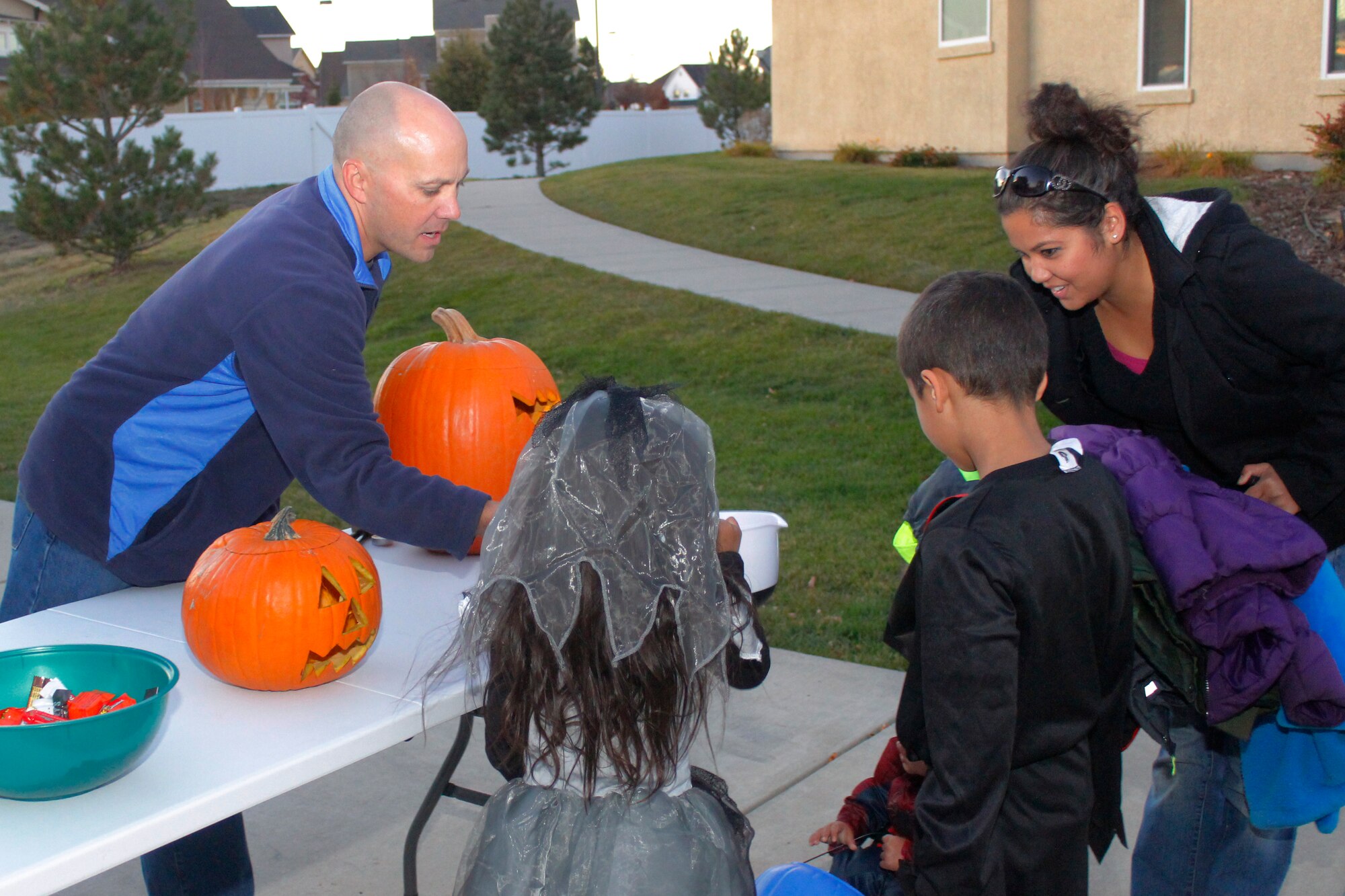 Col. Scott Romberger, 460th Space Wing vice commander, gives out candy to children in base housing Oct. 31, 2015, on Buckley Air Force Base, Colo. Children in base housing walked the neighborhood in costumes and received candy and treats from neighbors. (U.S. Air Force photo by Staff Sgt. Darren Scott/Released)