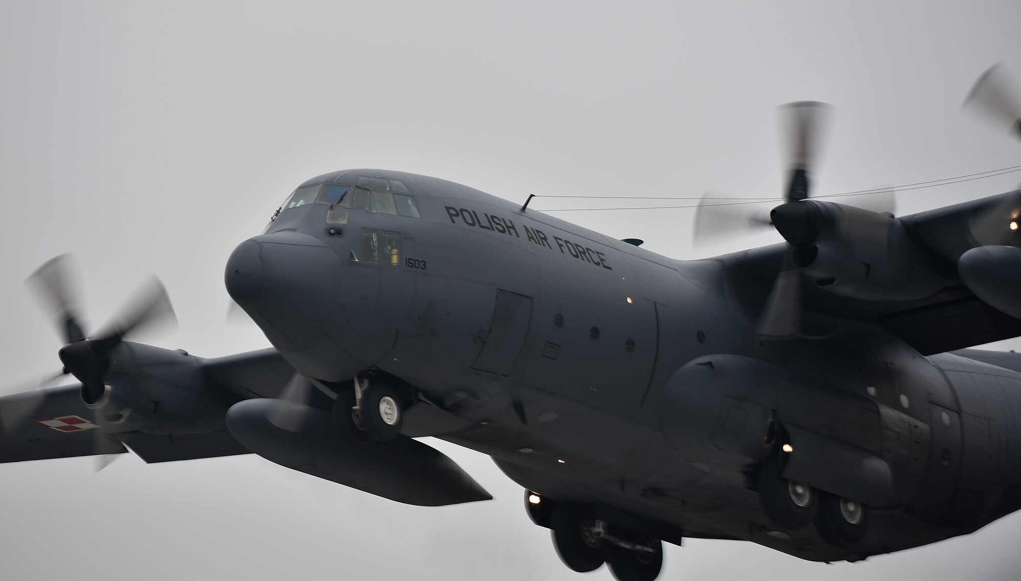 A Polish C-130E Legacy flies above the Powidz Air Base flight line in Poland as part of a friendly airlift competition during Aviation Detachment 16-1, Oct. 29, 2015. A variety of C-130s from three different units participated, including the 37th Airlift Squadron and 169th Airlift Squadron. (U.S. Air Force photo/Senior Airman Damon Kasberg)