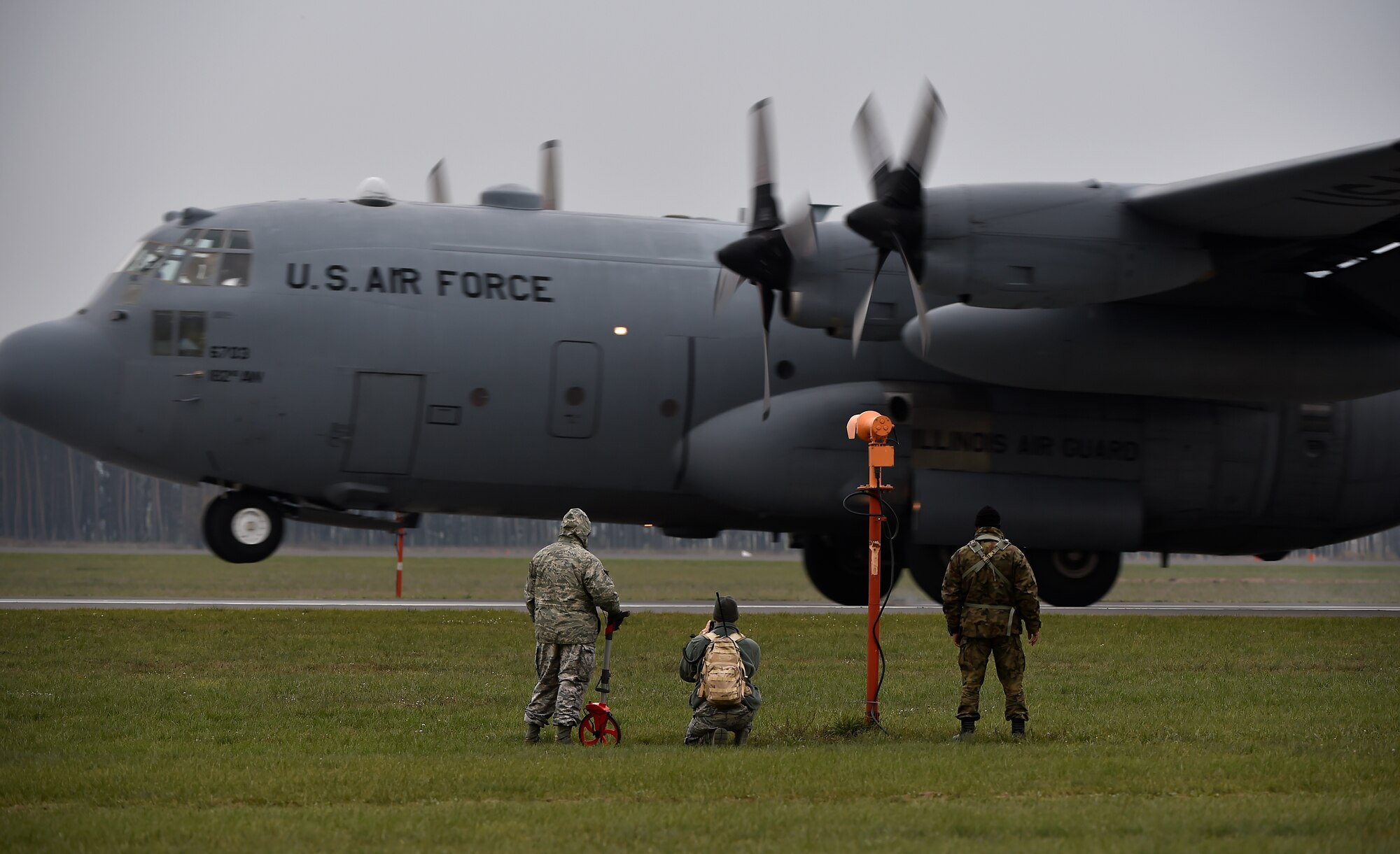 U.S. and Polish airmen watch as a C-130H Hercules, assigned to the 182nd Airlift Wing performs a tactical landing as part of a friendly airlift competition during Aviation Detachment 16-1, Oct. 29, 2015, at Powidz Air Base, Poland. The aircrew able to land the closest to the center point is declared the winner. The Polish air force placed first. (U.S. Air Force photo/Senior Airman Damon Kasberg)