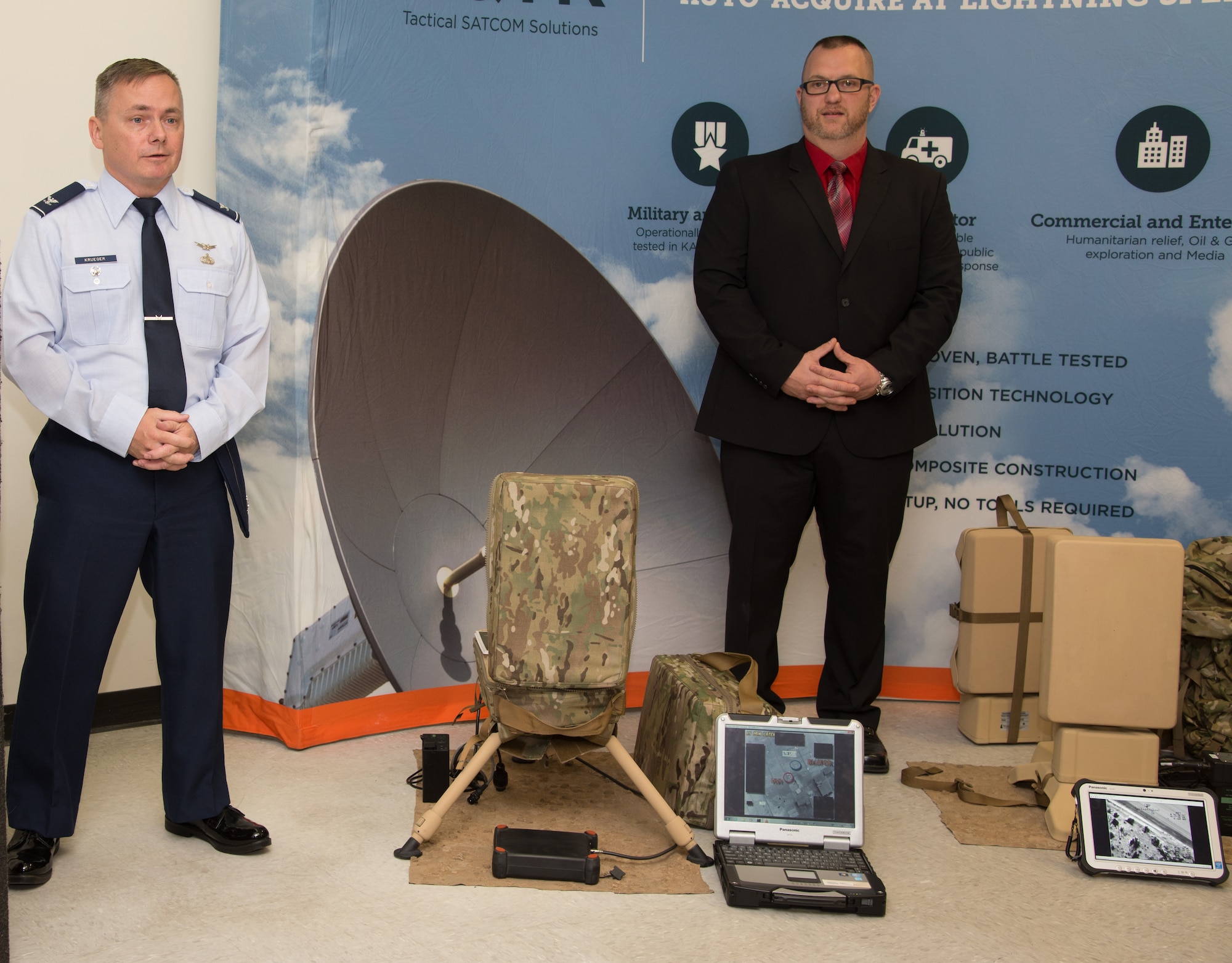 U.S. Air Force Col. Todd Krueger, Space, Aerial and Nuclear Networks senior materiel leader, and Jay Davison, AQYR Technologies director of government programs, discuss the new suitcase- and rucksack-portable receive suites that warfighters will use to receive secure data and cable-quality video when deployed to remote locations. The Global Broadcasting Service program office at Hanscom AFB, Mass., recently awarded a $14 million contract to AQYR Technologies for the production and delivery of 150 rucksack units. (U.S. Air Force photo by Mark Herlihy) 