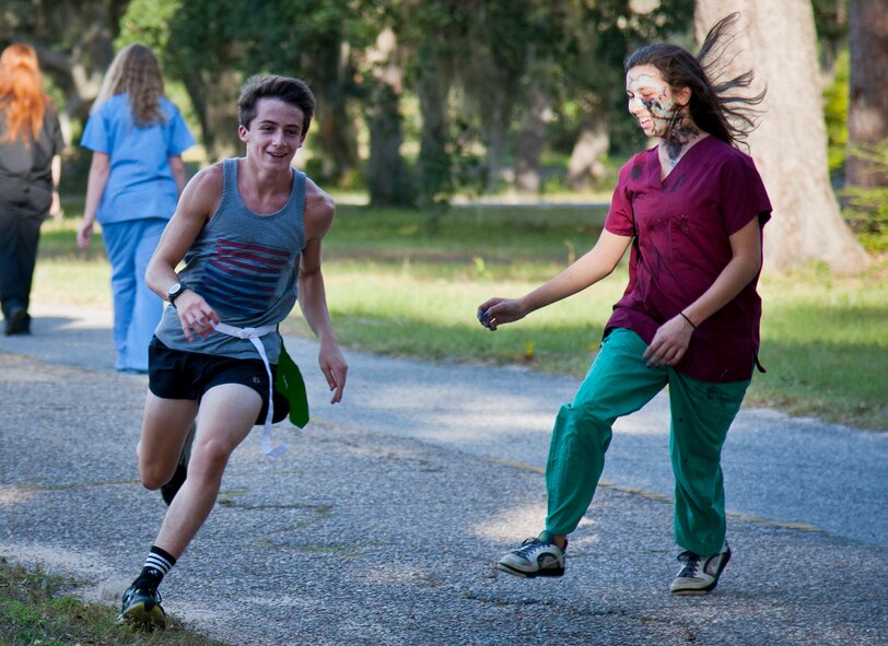 A participant is chased down by a zombie during the annual Zombie Stomp run Oct. 30 at Eglin Air Force Base, Fla.  More than 150 turned out to duck, dodge and outrun zombie hordes throughout the 5k run.  (U.S. Air Force photo/Samuel King Jr.)