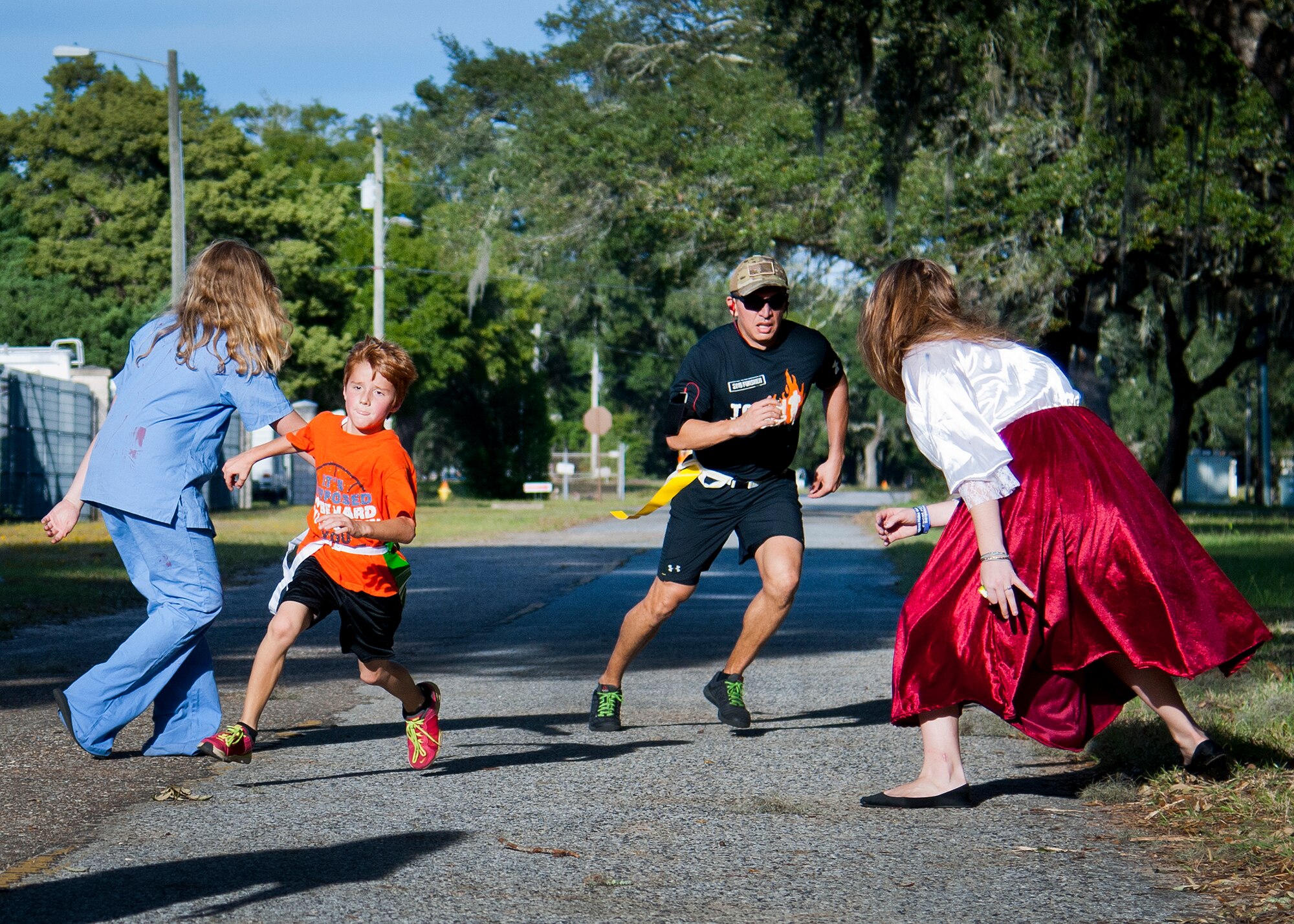Participants squeeze by two “walkers” during the annual Zombie Stomp run Oct. 30 at Eglin Air Force Base, Fla.  More than 150 turned out to duck, dodge and outrun zombie hordes throughout the 5k run.  (U.S. Air Force photo/Samuel King Jr.)
