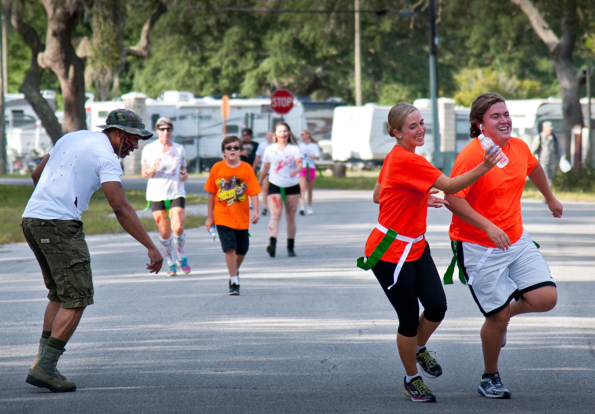 A couple tries to escape a hungry zombie during the annual Zombie Stomp run Oct. 30 at Eglin Air Force Base, Fla.  More than 150 turned out to duck, dodge and outrun zombie hordes throughout the 5k run.  (U.S. Air Force photo/Samuel King Jr.)