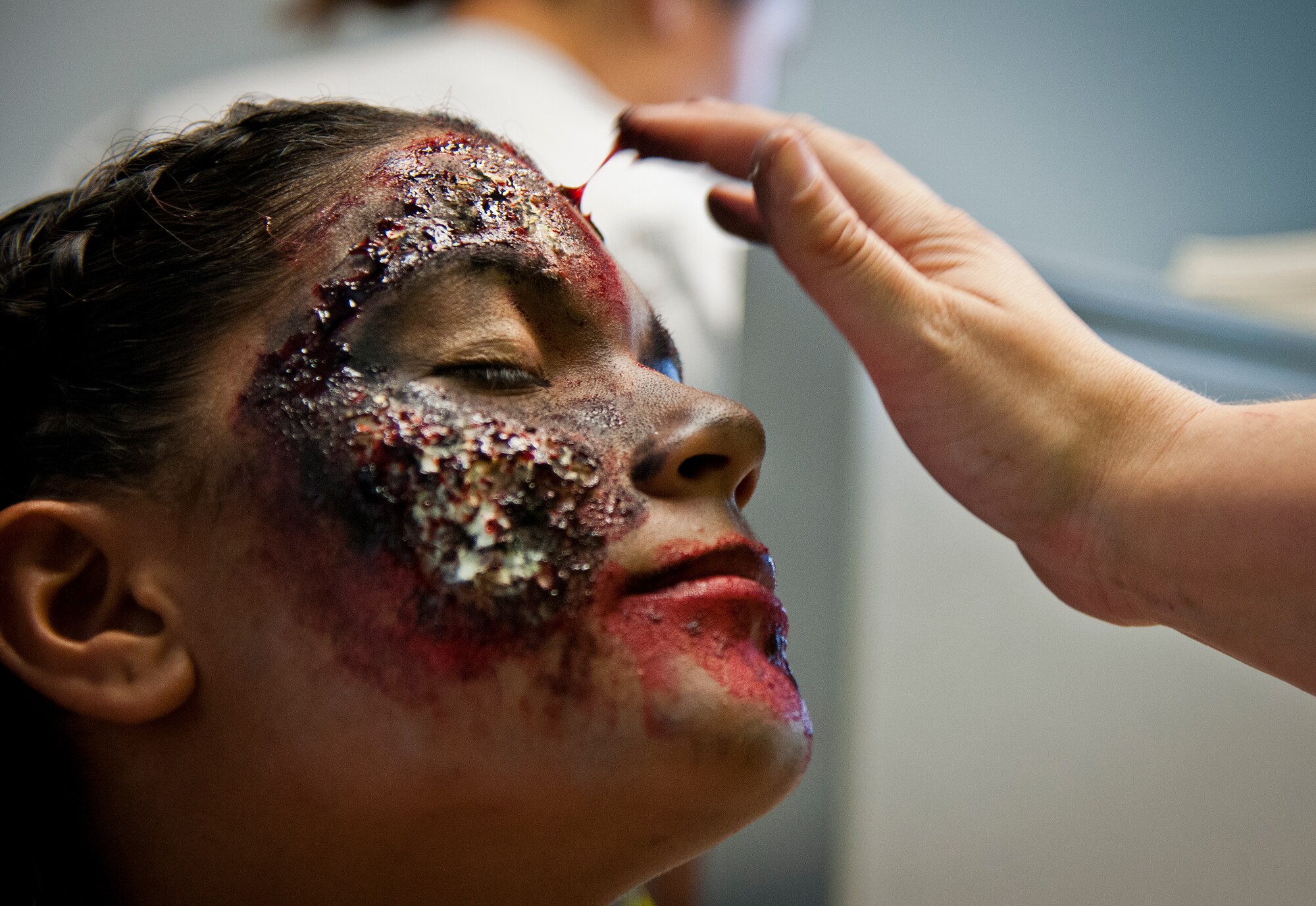 A volunteer puts the finishing touch on another zombie creation prior to the annual Zombie Stomp run Oct. 30 at Eglin Air Force Base, Fla.  More than 150 turned out to duck, dodge and outrun zombie hordes throughout the 5k run.  (U.S. Air Force photo/Samuel King Jr.)
