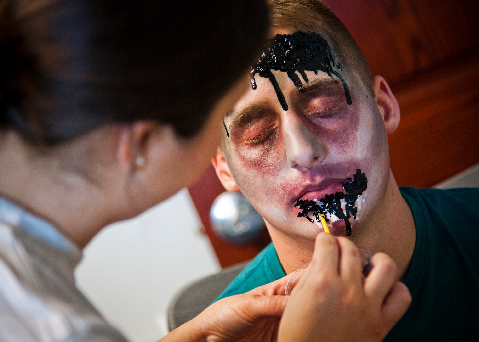 A volunteer places some blood drips to her zombie creation prior to the annual Zombie Stomp run Oct. 30 at Eglin Air Force Base, Fla.  More than 150 turned out to duck, dodge and outrun zombie hordes throughout the 5k run.  (U.S. Air Force photo/Samuel King Jr.)