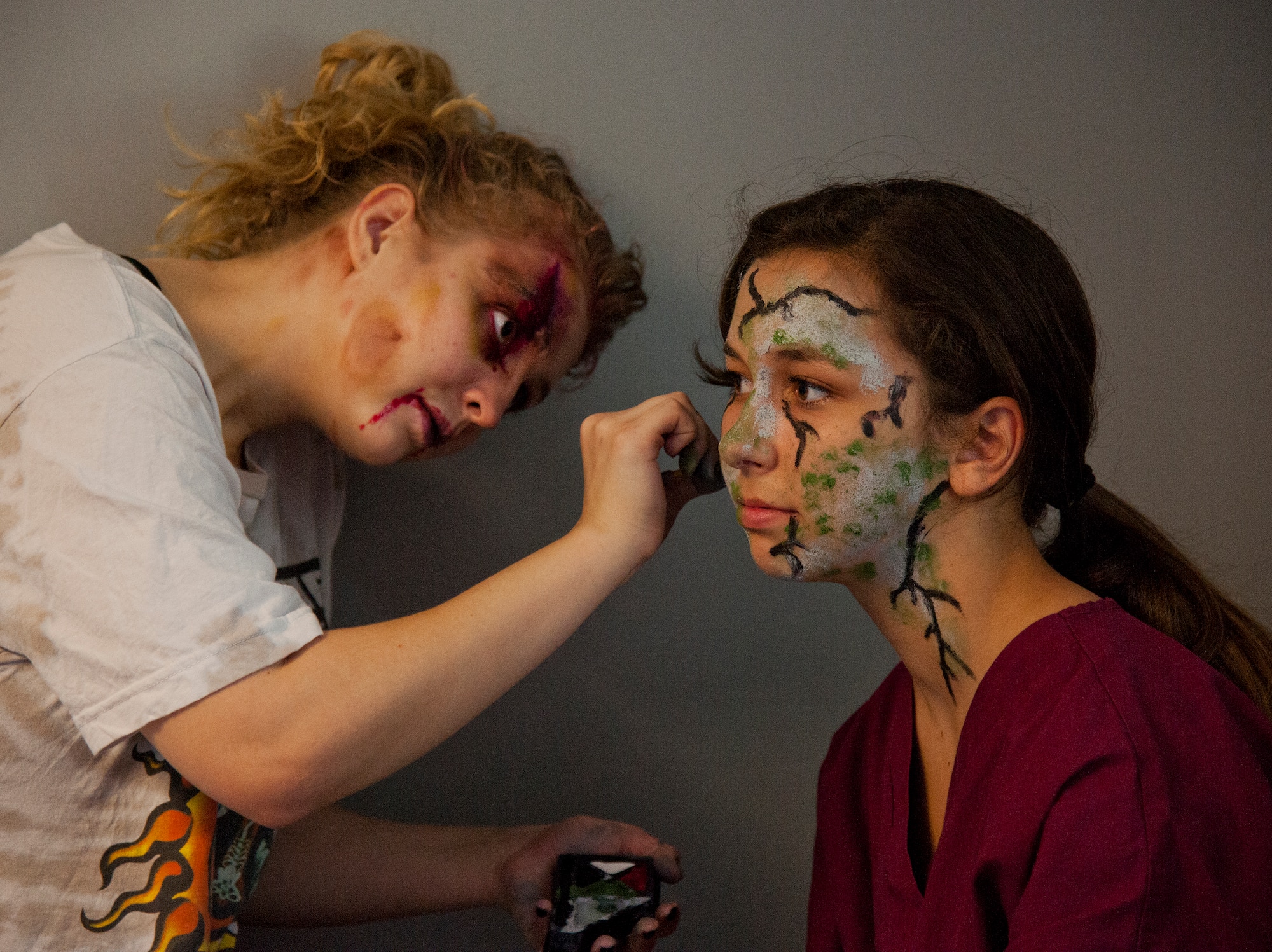 A zombie makeup artist turns another volunteer into the walking dead prior to the annual Zombie Stomp run Oct. 30 at Eglin Air Force Base, Fla.  More than 150 turned out to duck, dodge and outrun zombie hordes throughout the 5k run.  (U.S. Air Force photo/Samuel King Jr.)