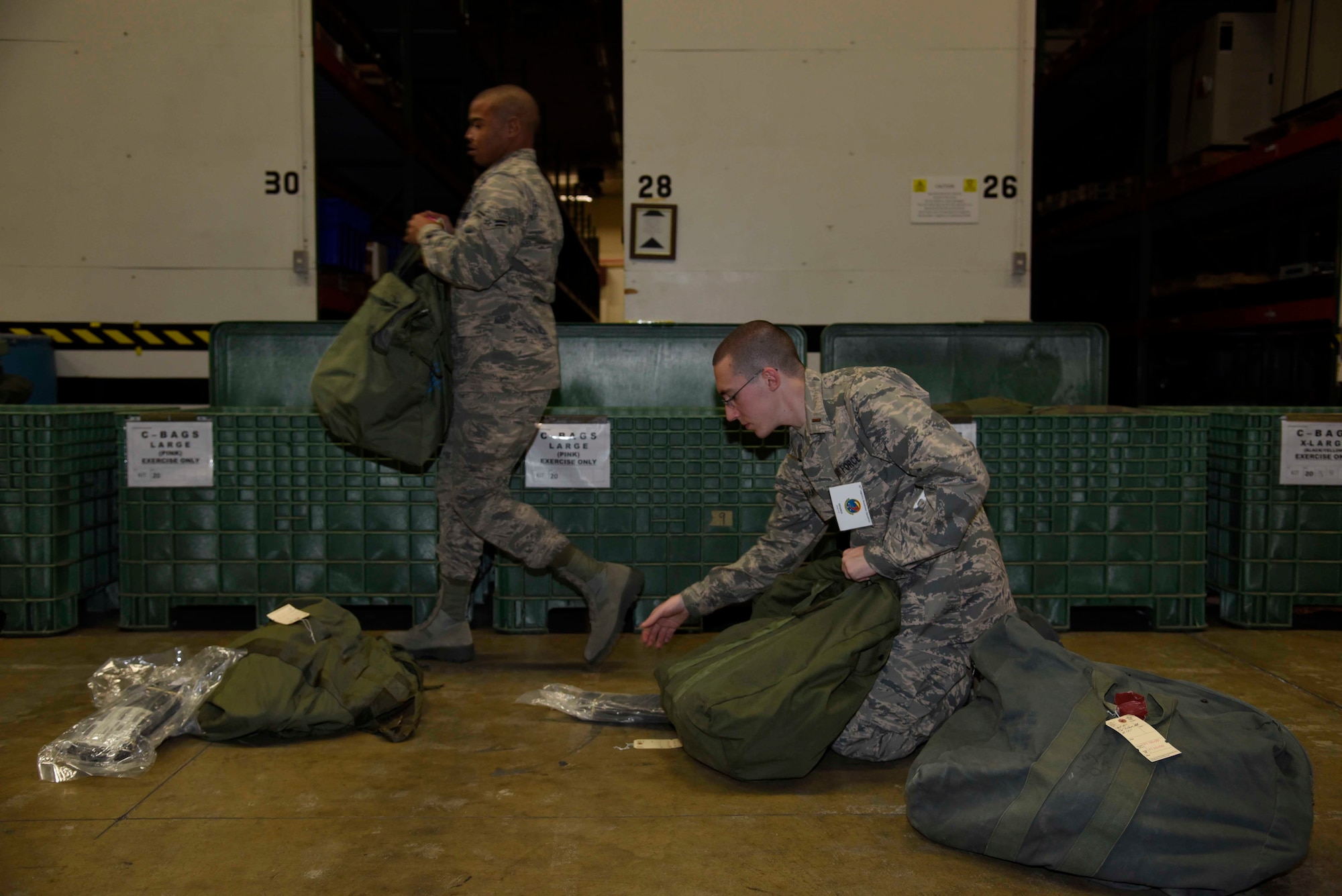 Airmen with the 35th Logistics Readiness Squadron assemble mission oriented protective posture equipment bags during exercise Beverly Sunrise 16-01 at Misawa Air Base, Japan, Nov. 1, 2015. The gear consists of body armor, overboots, protective masks and gloves used to protect personnel from chemical, biological, radiological and nuclear threats. (U.S. Air Force photo by Airman 1st Class Jordyn Fetter/Released)