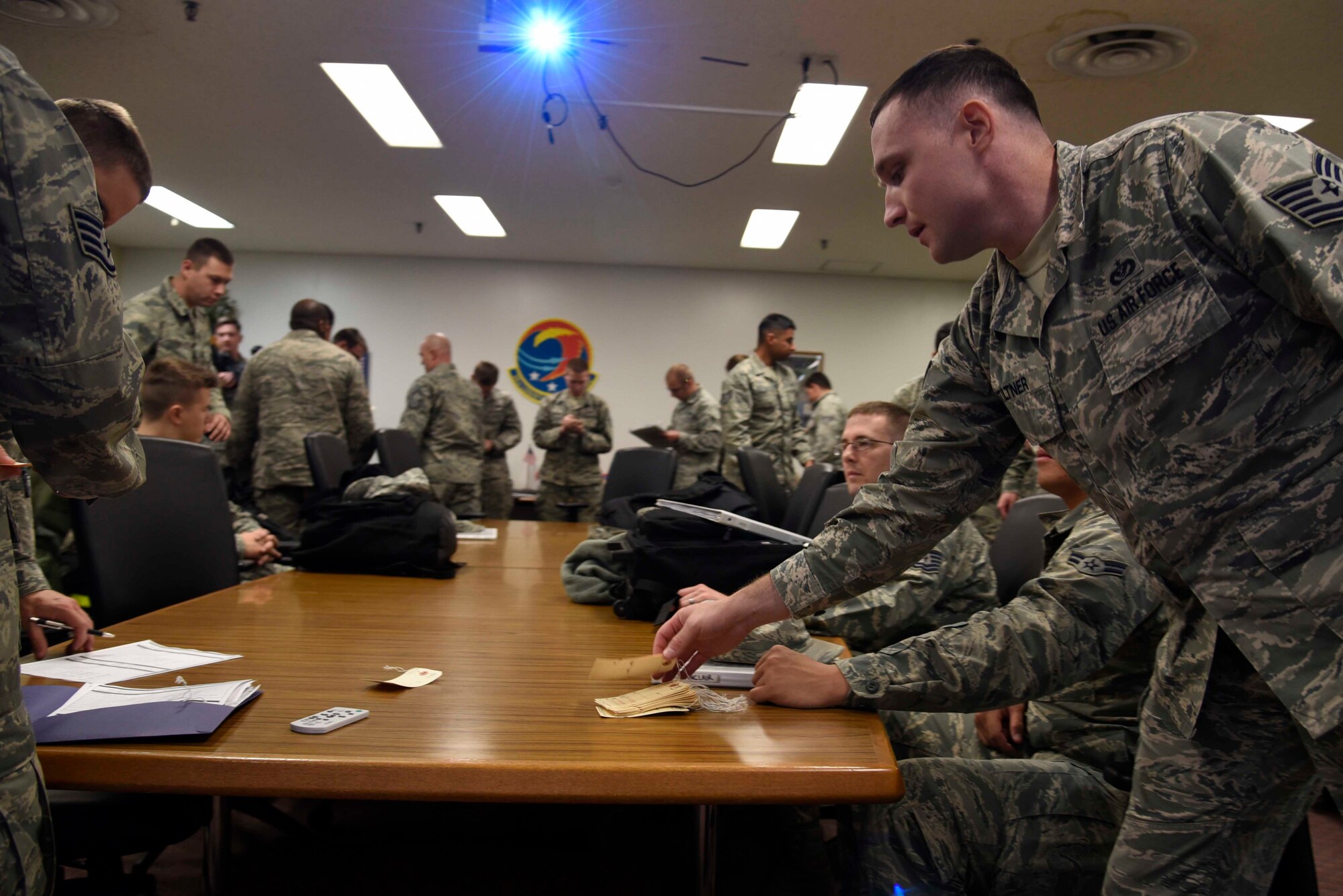 Airmen from the 35th Fighter Wing prepare forms and tags while going through the personnel deployment function line during exercise Beverly Sunrise 16-01 at Misawa Air Base, Japan, Nov. 1, 2015. During Phase 1 of the exercise, more than 300 Airmen were out-processed for a deployment to Osan Air Base, South Korea, exercising what a real-world contingency operation could look like. (U.S. Air Force photo by Airman 1st Class Jordyn Fetter/Released)