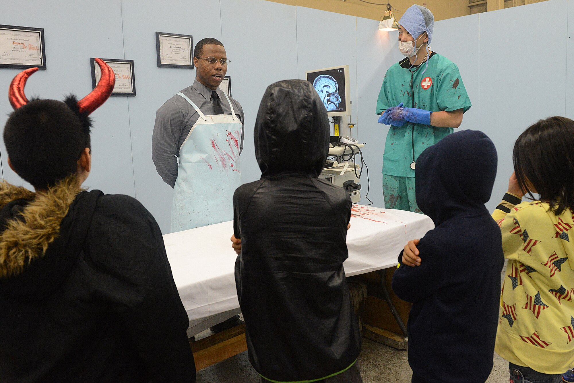 Staff Sgt. Julius McCray, 374th Airlift Wing unit deployment manager, role-plays as a mad psychiatrist at Yokota Air Base, Japan, Oct. 31, 2015. Children from the Shisei Gakusha Tachikawa Orphanage went through the child friendly version of the 'Yokota Insane Asylum' haunted house during a Halloween visit arranged by the 374th Maintenance Group.(U.S. Air Force photo by Senior Airman David C. Danford/Released)