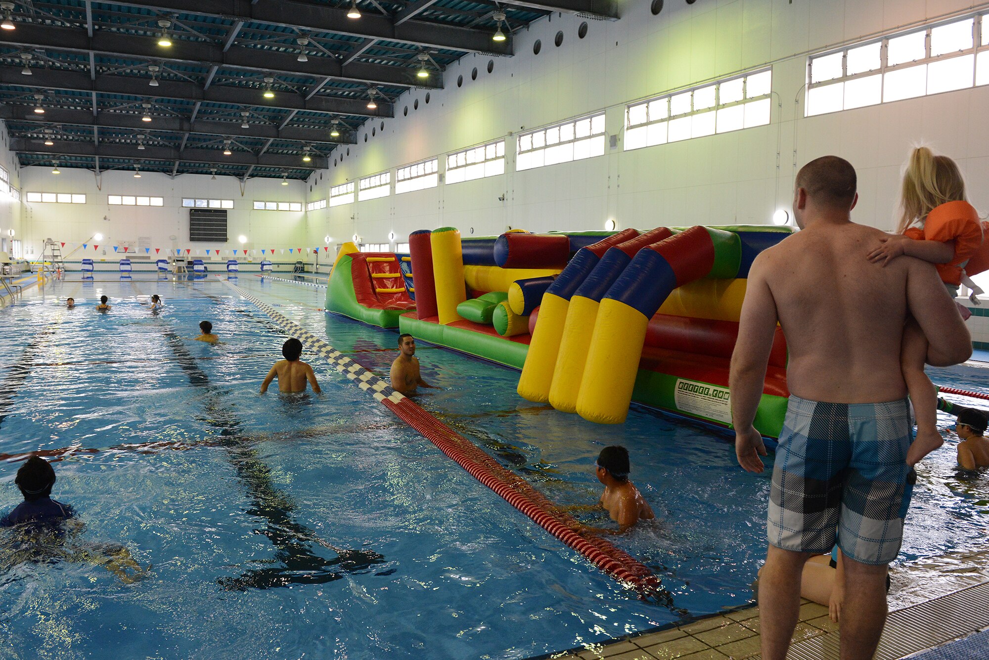 Volunteers from the 374th Maintenance Group chaperone children from the Shisei Gakusha Tachikawa Orphanage while they swim at Yokota Air Base, Japan, Oct. 31, 2015. During the Halloween visit, the children swam at the natatorium, played on bouncy castles and went through the child friendly version of the 'Yokota Insane Asylum' haunted house. (U.S. Air Force photo by Senior Airman David C. Danford/Released)