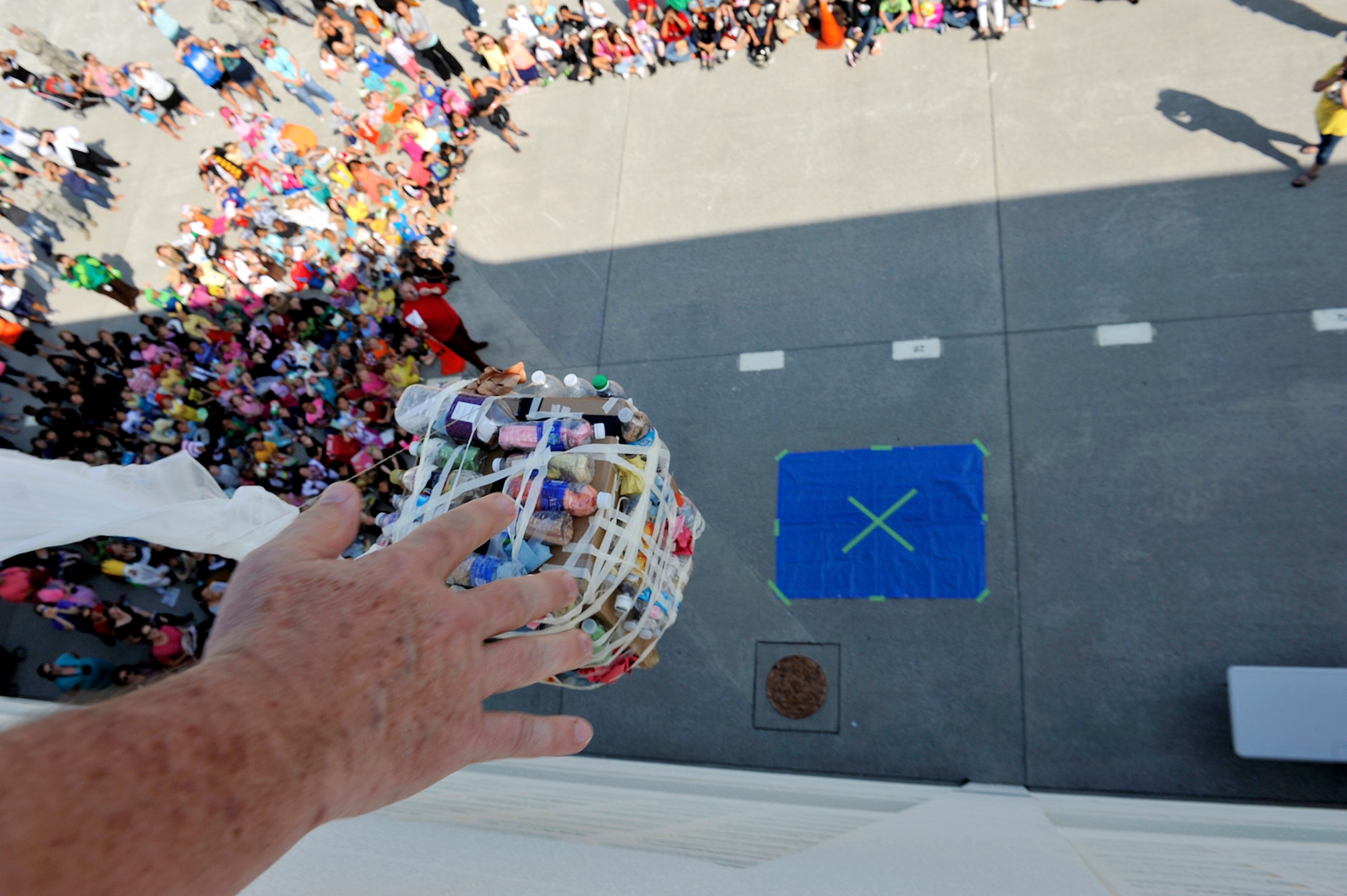Stearley Heights Elementary School teacher drops a pumpkin in a container from the top of the building Oct. 30, 2015, at Kadena Air Base, Japan. The 5th grade children worked in teams to generate a container to protect their pumpkin from breaking after being dropped from top of the building. (U.S. Air Force photo by Naoto Anazawa)