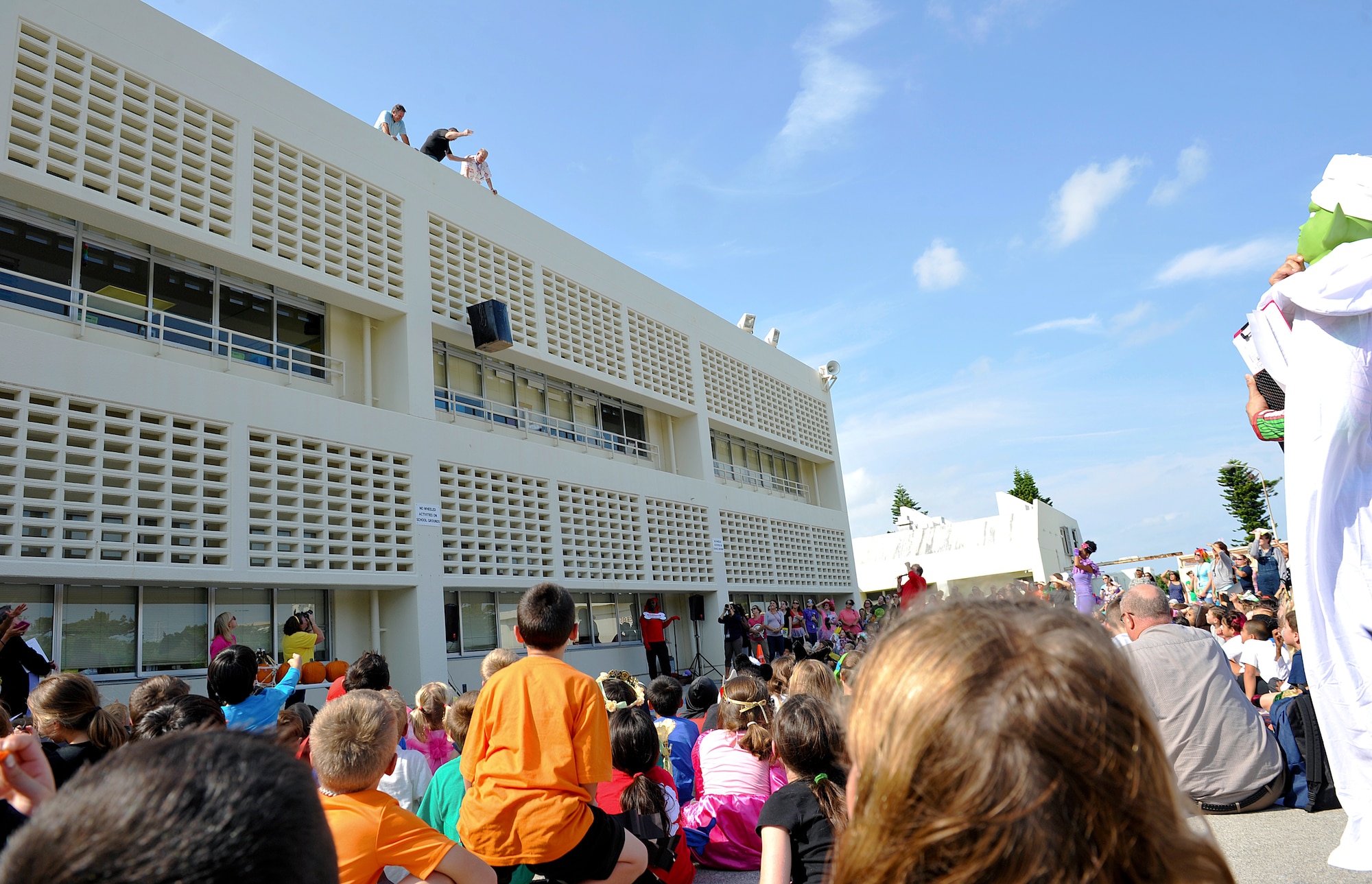 More than 500 children from Stearley Heights Elementary School and their parents observe a pumpkin drop after the storybook character parade at Stearley Heights Elementary School Oct. 30, 2015, at Kadena Air Base, Japan. As part of a science experiment children and their parents observed pumpkins being dropped from the top of the school as part of the festivities. (U.S. Air Force photo by Naoto Anazawa)