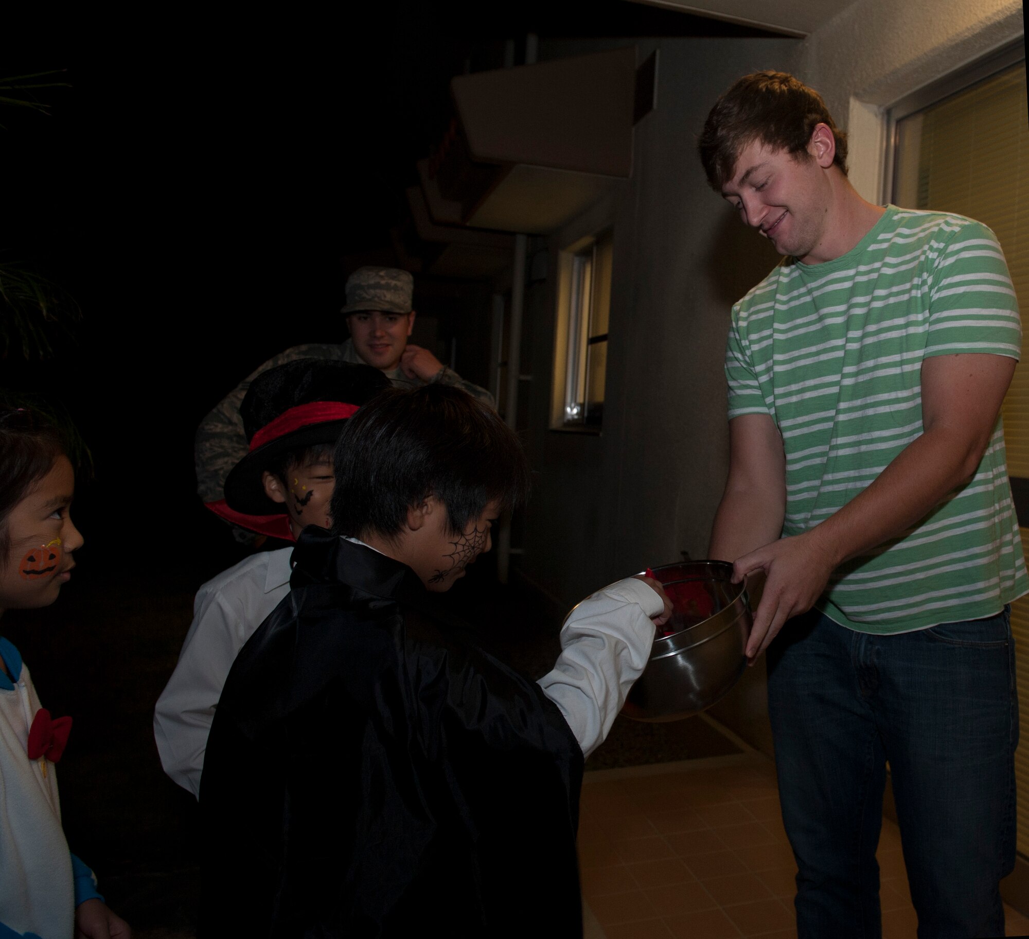 Tyler Neal, a military spouse, gives candy to local Okinawan trick-or-treaters Oct. 31, 2015, at Kadena Air Base, Japan. Kadena had the opportunity to participate in Halloween festivities with the local Okinawan community. Events like this help bolster the U.S. Japan relationship. (U.S. Air Force photo by Airman 1st Class Lynette M. Rolen)