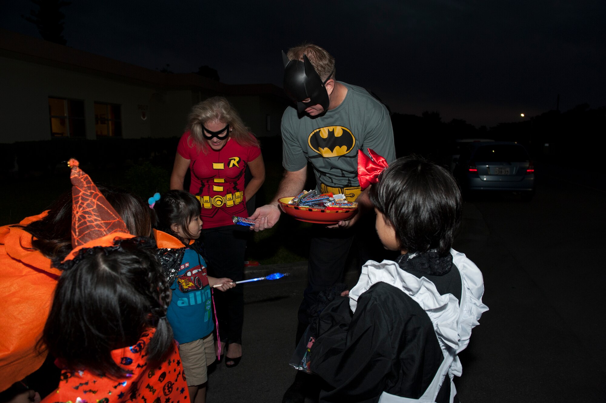 U.S. Air Force Col. James Lasswell, 18th Medical Group commander, along with his wife, Katie, pass out candy to local Okinawan children Oct. 31, 2015, at Kadena Air Base, Japan. The children were taught the famous Halloween saying of “trick-or-treat” and received candy from Kadena’s families on Halloween night. (U.S. Air Force photo by Airman 1st Class Lynette M. Rolen)