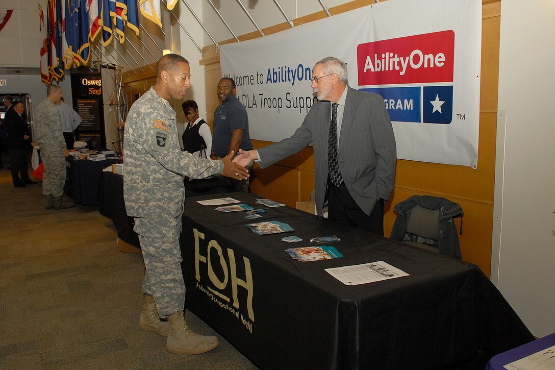 Army Brig. Gen. Charles R. Hamilton, commander of DLA Troop Support greets a vendor from the Federal Occupational Health organization at the AbilityOne Day expo Oct. 28 in Philadelphia. The event was held to increase awareness of the outstanding contributions people with disabilities have made to our nation and to highlight the products and services provided to our warfighters.