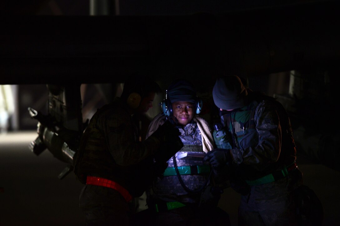 U.S. Air Force Staff Sgt. Tamika Lindsey, center, reviews system operational guidelines with the crew before night operations during Vigilant Ace 16 on Osan Air Base, South Korea, Nov. 2, 2015. Lindsey is a load master assigned to the 25th Aircraft Maintenance Unit. U.S. Air Force photo by Staff Sgt. Amber Grimm