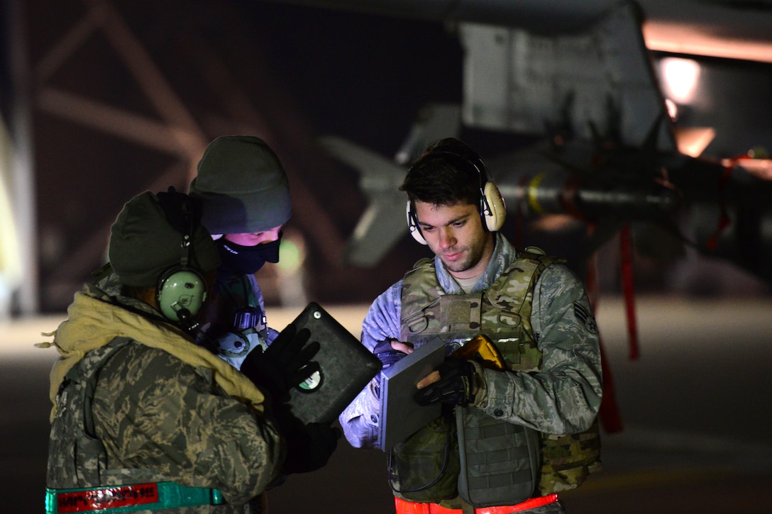 U.S. Air Force Senior Airman Jonathon Simmons, right, reviews system operational guidelines with the crew before night operations during Vigilant Ace 16 on Osan Air Base, South Korea, Nov. 2, 2015. Simmons is a load master assigned to the 25th Aircraft Maintenance Unit. U.S. Air Force photo by Staff Sgt. Amber Grimm