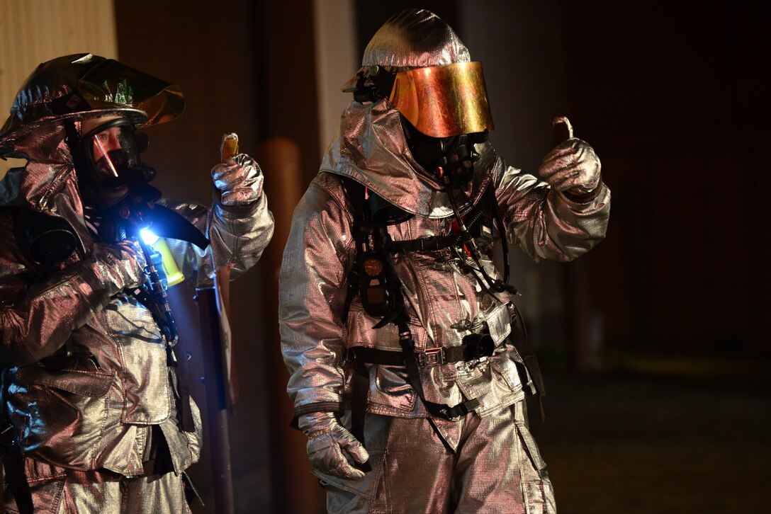 U.S. airmen give a thumbs up to indicate successful completion of  buddy checks before a secondary sweep of a simulated burning building during Vigilant Ace 16 on Osan Air Base, South Korea, Nov. 3, 2015. The airmen are firefighters assigned to the 51st Civil Engineer Squadron. U.S. Air Force photo by Staff Sgt. Amber Grimm