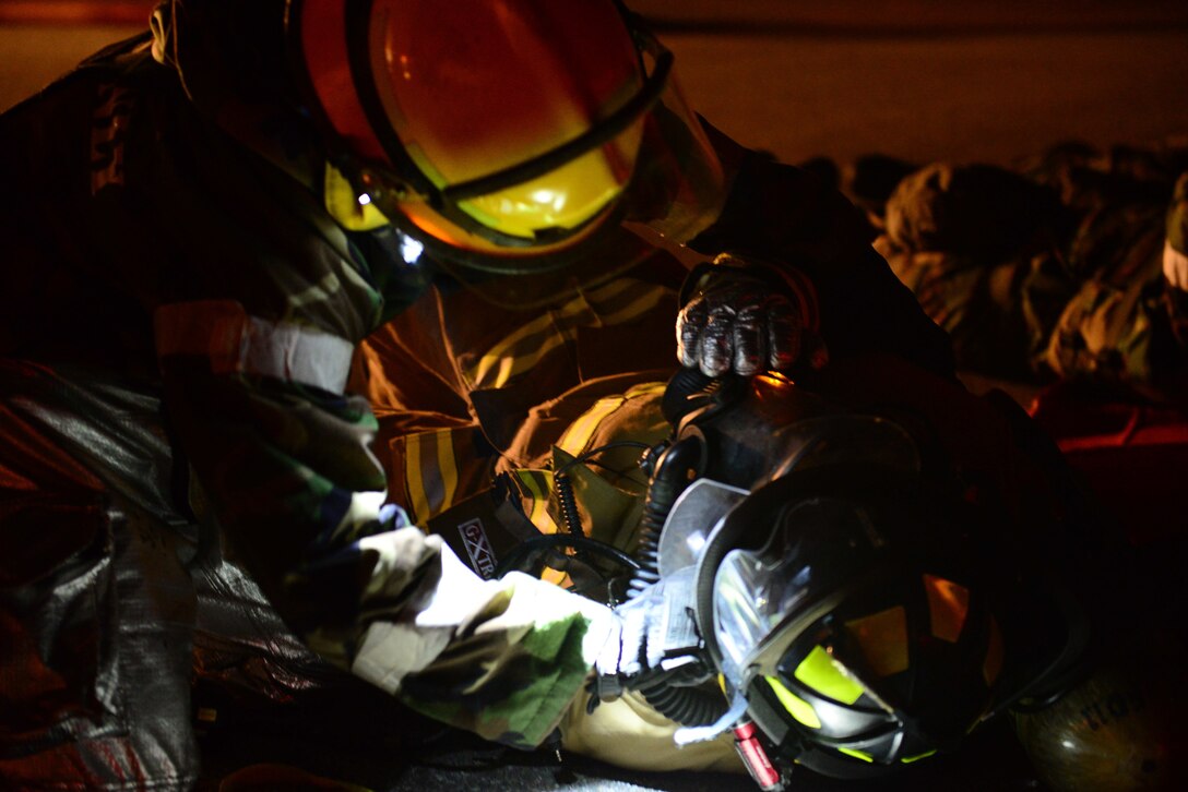 U.S. airmen perform first aid on a fellow firefighter during a mock building fire, part of Vigilant Ace 16 on Osan Air Base, South Korea, Nov. 3, 2015. U.S. Air Force photo by Staff Sgt. Amber Grimm